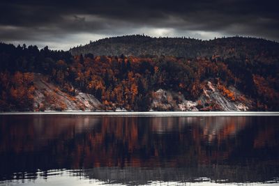 Scenic view of lake by mountain against sky