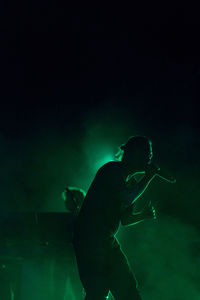 Rear view of man at music concert at night