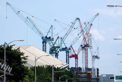 Cranes at construction site against sky