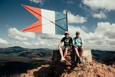 People standing on mountain against sky