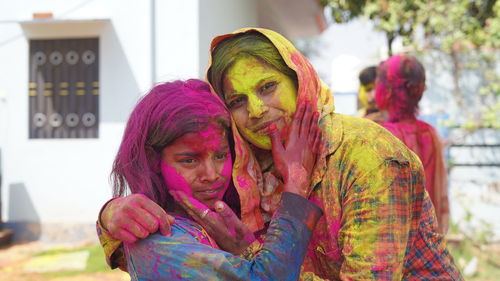 Happy mother enjoying time with her daughter during holi festival at home