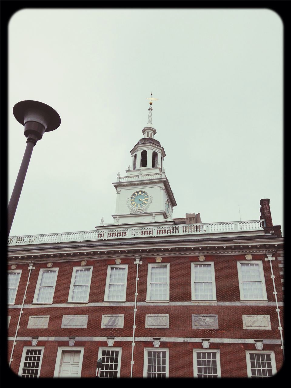 transfer print, architecture, building exterior, built structure, low angle view, auto post production filter, clear sky, street light, sky, tower, clock tower, city, high section, religion, clock, communication, day, window, tall - high, outdoors