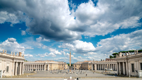 Buildings in city against cloudy sky