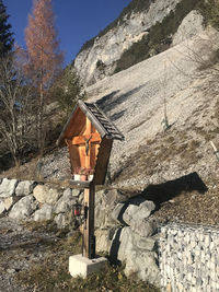 Cross on rock against trees