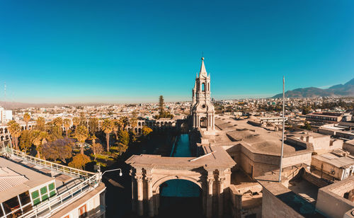 Buildings in city against clear blue sky