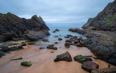 Rocks on beach against sky