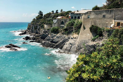 Scenic view of sea by buildings against sky