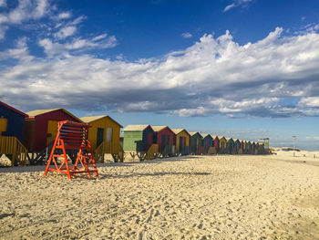 Beach huts by sea against sky