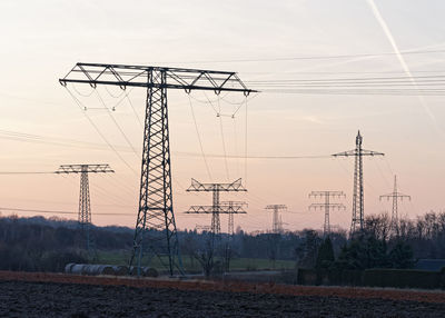 Low angle view of electricity pylon on field against sky