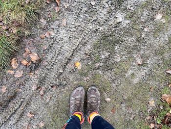 Low section of person standing on messy land
