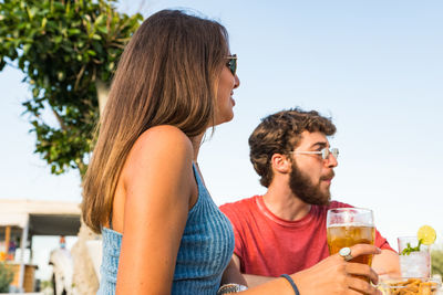 Man and woman drinking glasses outdoors