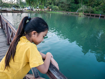 Girl standing over lake on pier