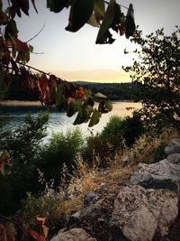 Scenic view of lake against sky at sunset