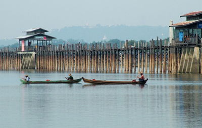 People on boat in sea against sky