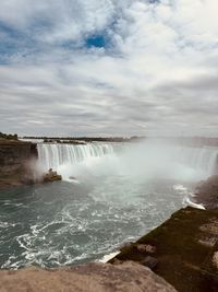 Scenic view of waterfall against sky