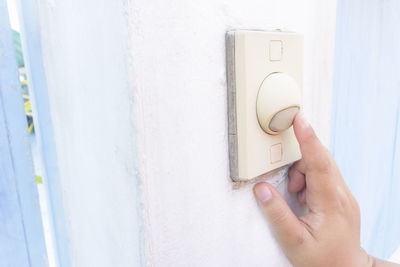 Cropped hand pressing doorbell