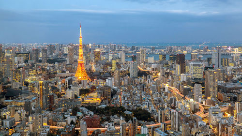 Aerial view of city buildings against cloudy sky