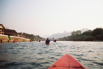 Rear view of people kayaking on river