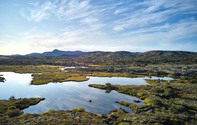 Majestic scenery of winding river on plain against highland in sunny day