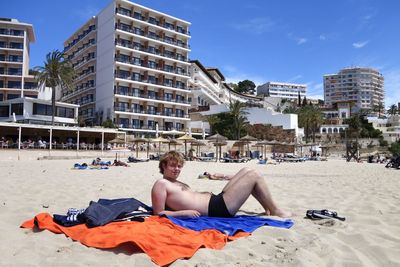 High angle view of shirtless lying on beach