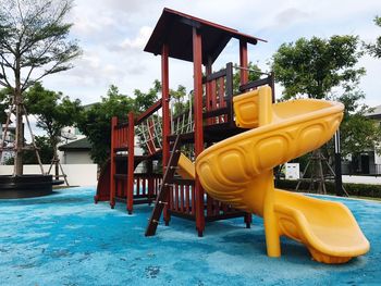 Empty playground against trees in park