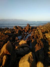 Scenic view of rocks on beach against sky