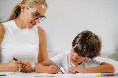 Child coloring shapes in a preschool assessment test.