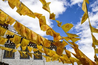 Low angle view of flags hanging against sky