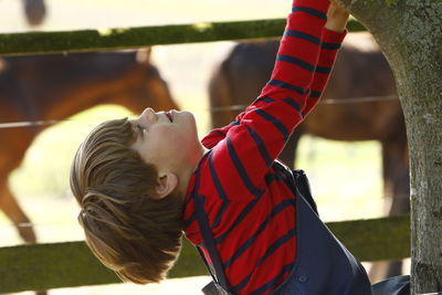 Close-up of boy looking up outdoors