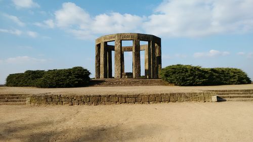 War memorial on field against sky