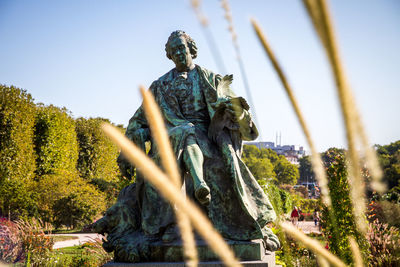 Statue in park against sky