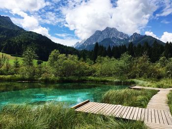 Scenic view of lake by mountains against sky