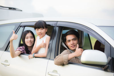 Portrait of family gesturing in car