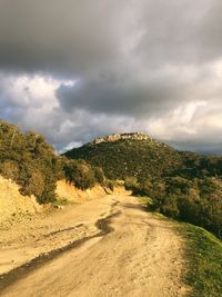 Scenic view of land against cloudy sky