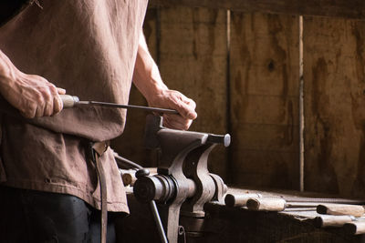 Midsection of man working in workshop