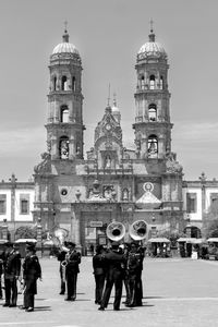 People in front of cathedral with musical instruments