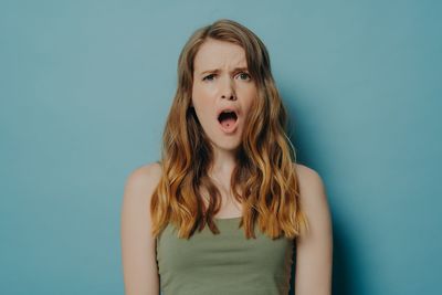 Portrait of teenage girl against blue background