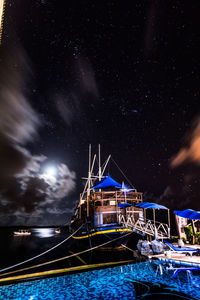 Illuminated ship in sea against sky at night