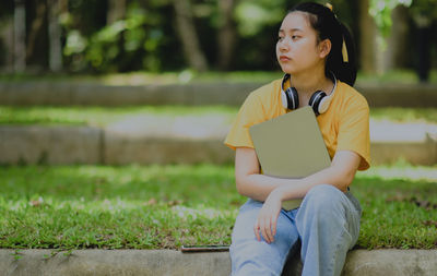 A teenage woman holding a tablet with a worried expression, asian teenager, educational concept.