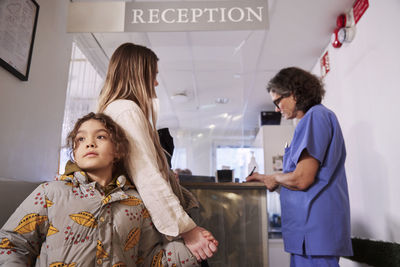 Female doctor with patients at reception desk
