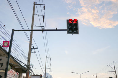 Low angle view of road signal against sky