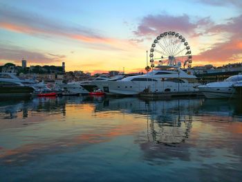 Boats moored at harbor against sky during sunset