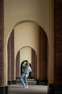 Full length of woman standing against building