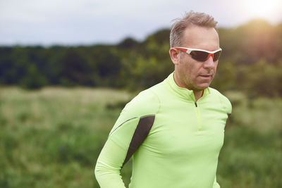 Man wearing sunglasses while jogging on field