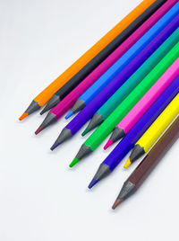 High angle view of colored pencils on white background