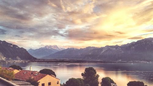 Scenic view of lake and mountains against sky during sunset