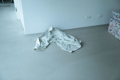 High angle view of white fabric on bed against wall