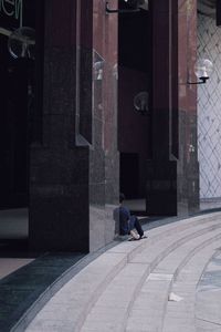 People walking on footpath by building in city