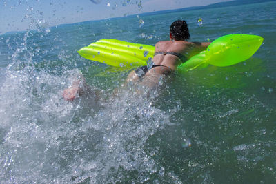 Woman with inflatable raft in swimming pool