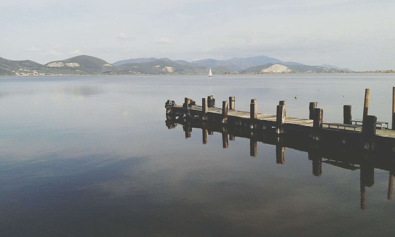 water, mountain, lake, tranquility, tranquil scene, pier, mountain range, scenics, sky, beauty in nature, reflection, nature, wood - material, waterfront, wooden post, jetty, idyllic, calm, non-urban scene, sea